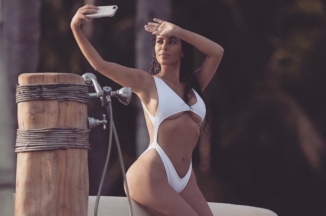 Kim Kardashian tirando selfie de biquíni branco
