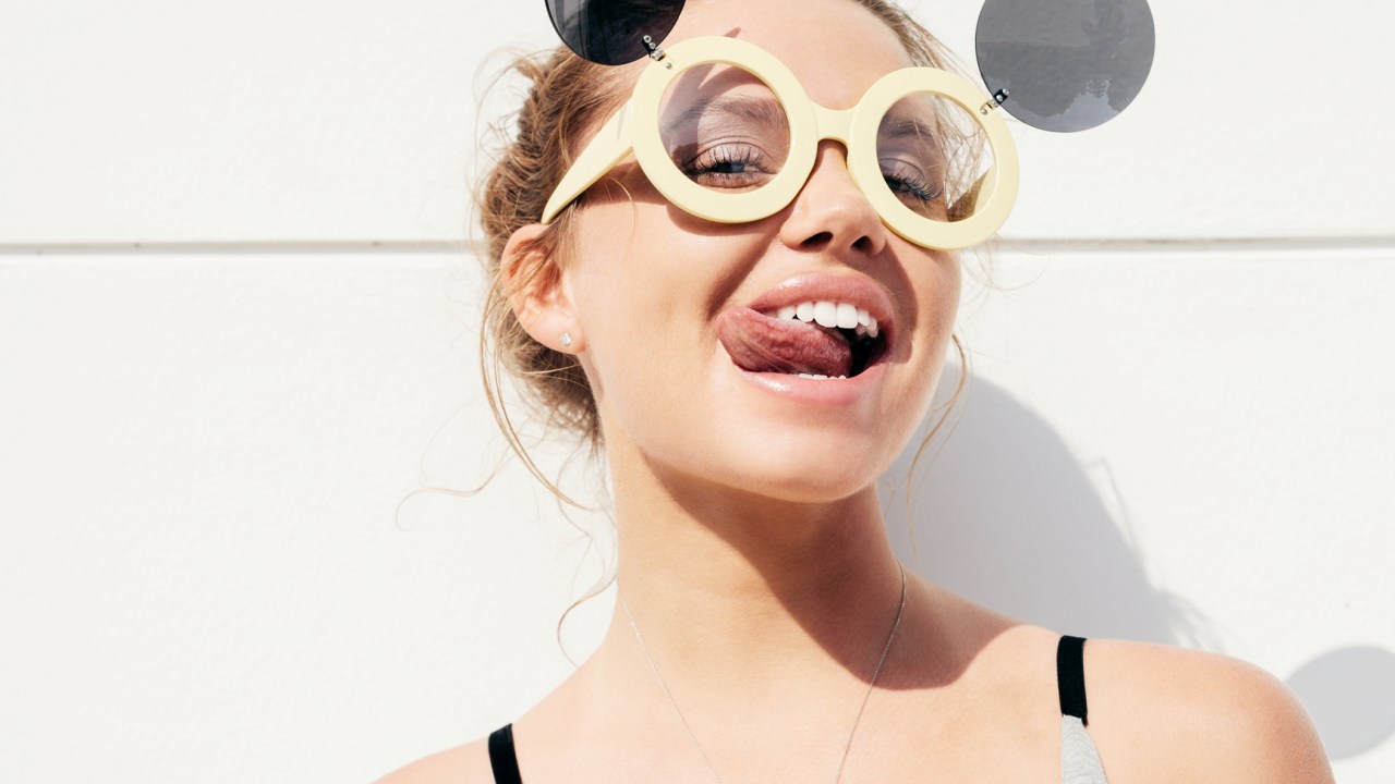 Mulher mostrando a língua pra fora com óculos