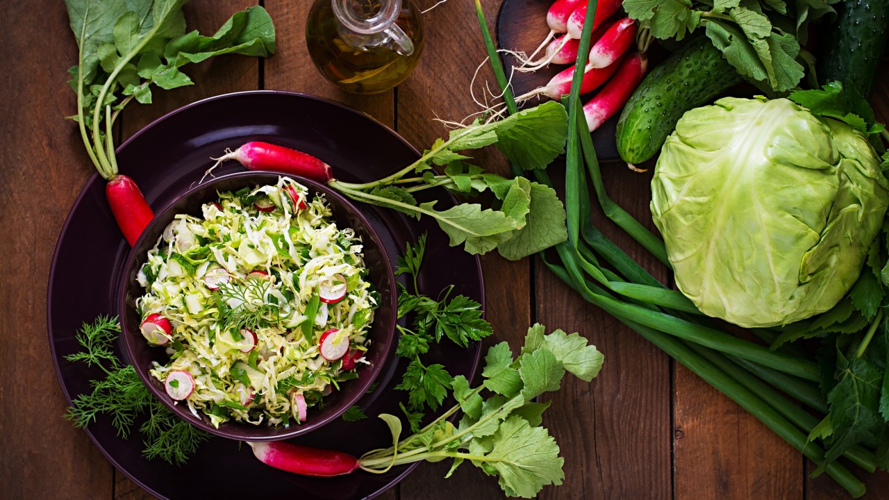 Verduras e vegetais orgânicos na bancada de madeira da cozinha