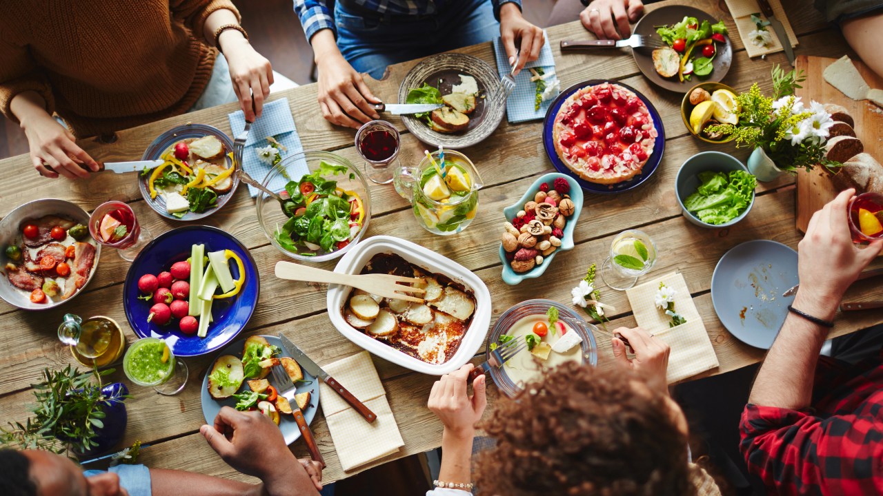 Grupo de amigos sentados à mesa com comida saudável