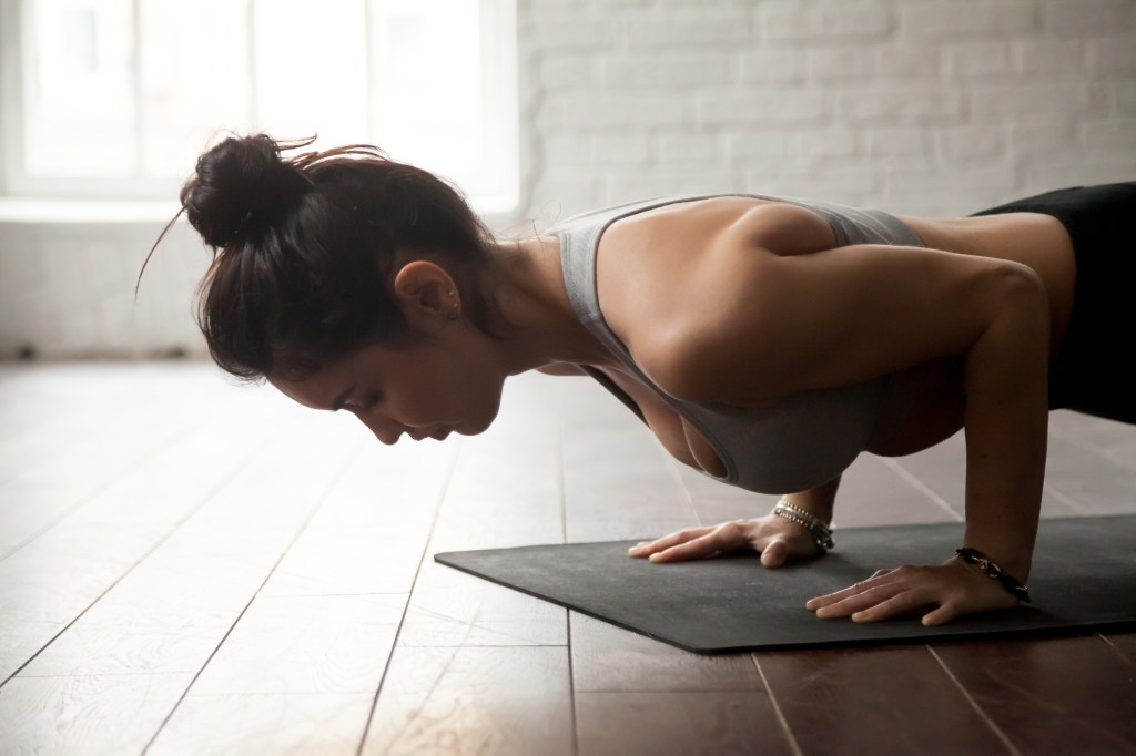 Mulher fazendo ioga em um estúdio em posição de prancha