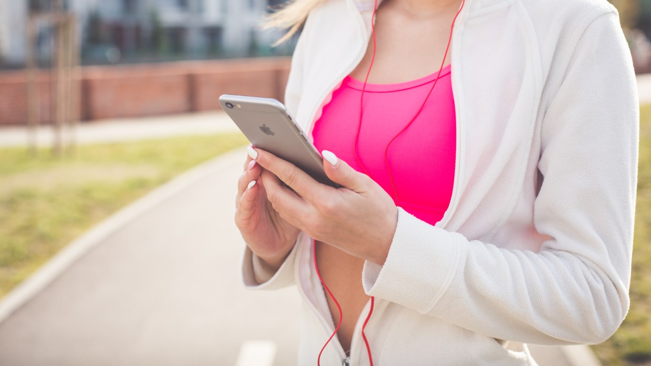 Mulher com roupas esportivas ouvindo música - músicas para treinar de acordo com seu batimento cardíaco
