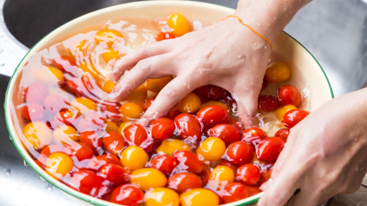 Pessoa lavando tomates