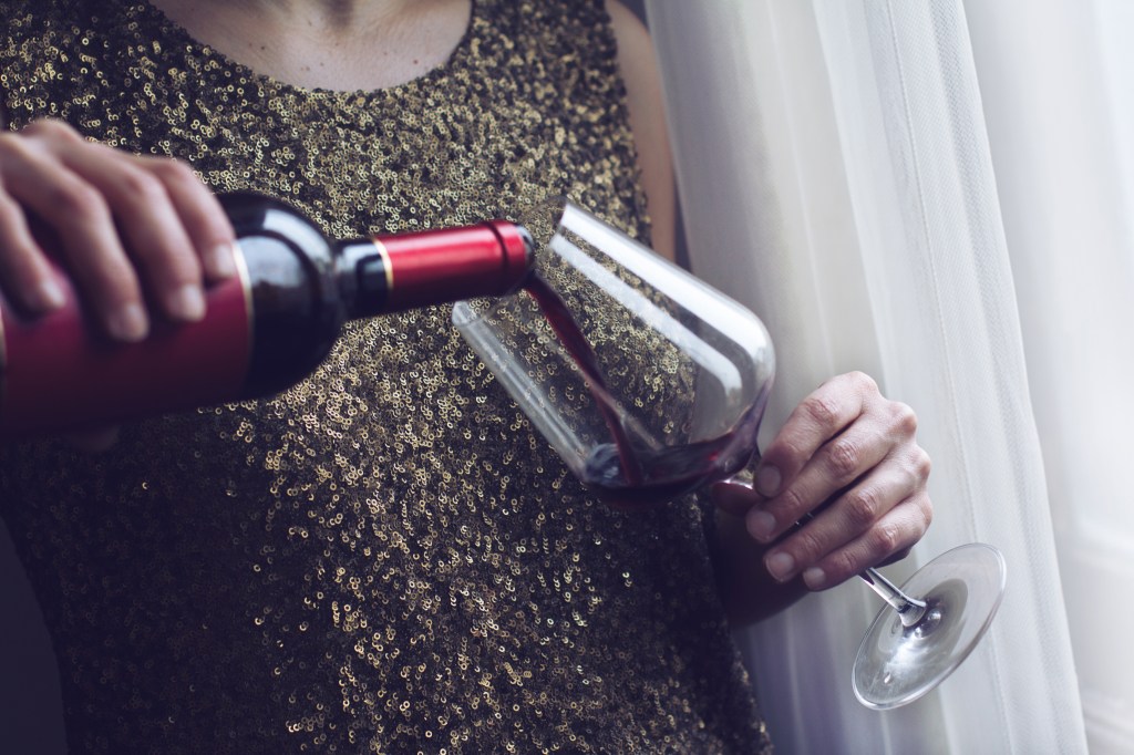 Mulher colocando vinho na taça