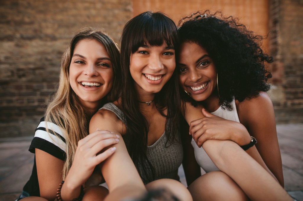 Três mulheres com cor de pele diferente fazendo selfie