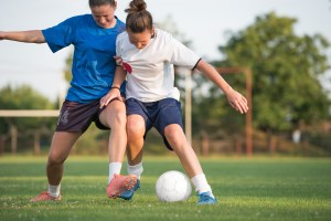 Mulheres jogando futebol com bola