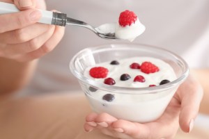 mulher comendo iogurte com frutas