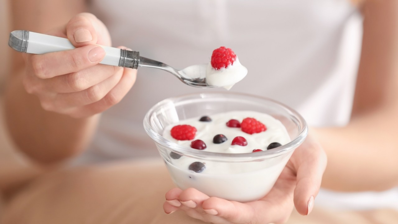mulher comendo iogurte com frutas