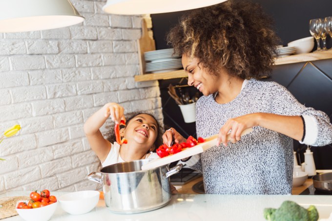 Mãe e criança cozinhando e felizes