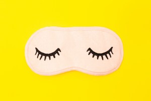 Directly Above Shot Of Eye Mask Over Yellow Background