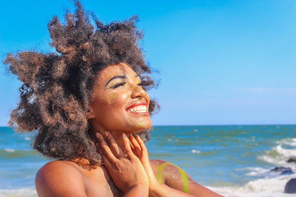 Imagem ilustrativa de uma mulher sorrindo na praia