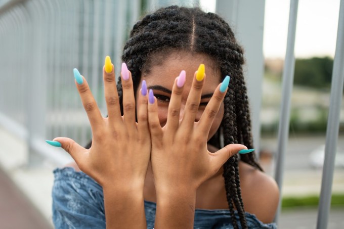 Model on city bridge posing with colorful nails