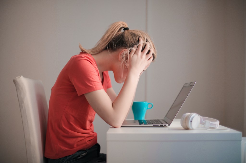mulher angustiada sentada na frente do computador