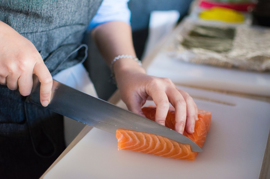 mulher cortando salmão