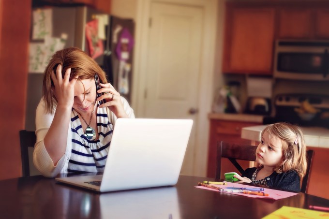 Woman frustrated at computer while daughter watches concerned