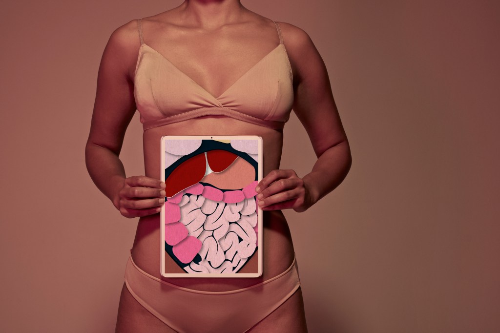 mulher segurando cartaz com desenho do intestino