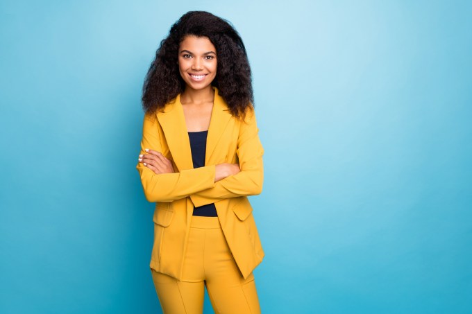 Photo of beautiful dark skin business lady holding hands crossed self-confident bossy person worker wear stylish yellow office costume isolated blue color background