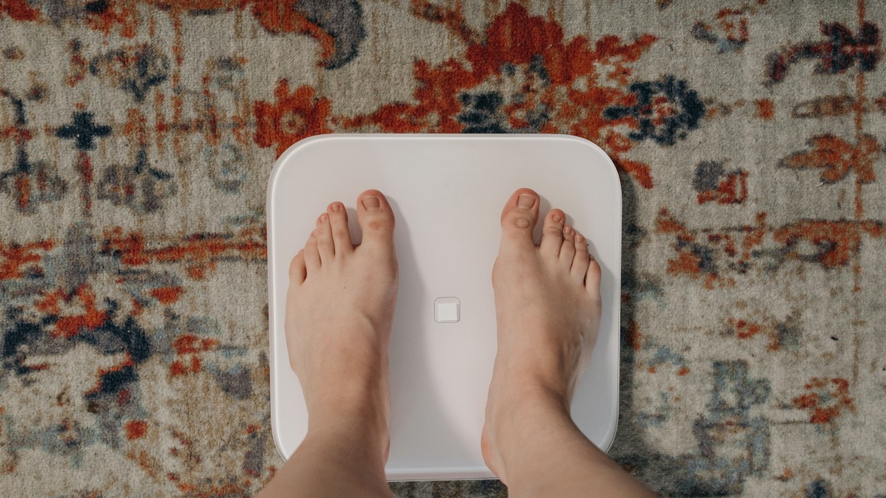 pés de pessoa branca sobre balanca, se pesando para perder peso rápido