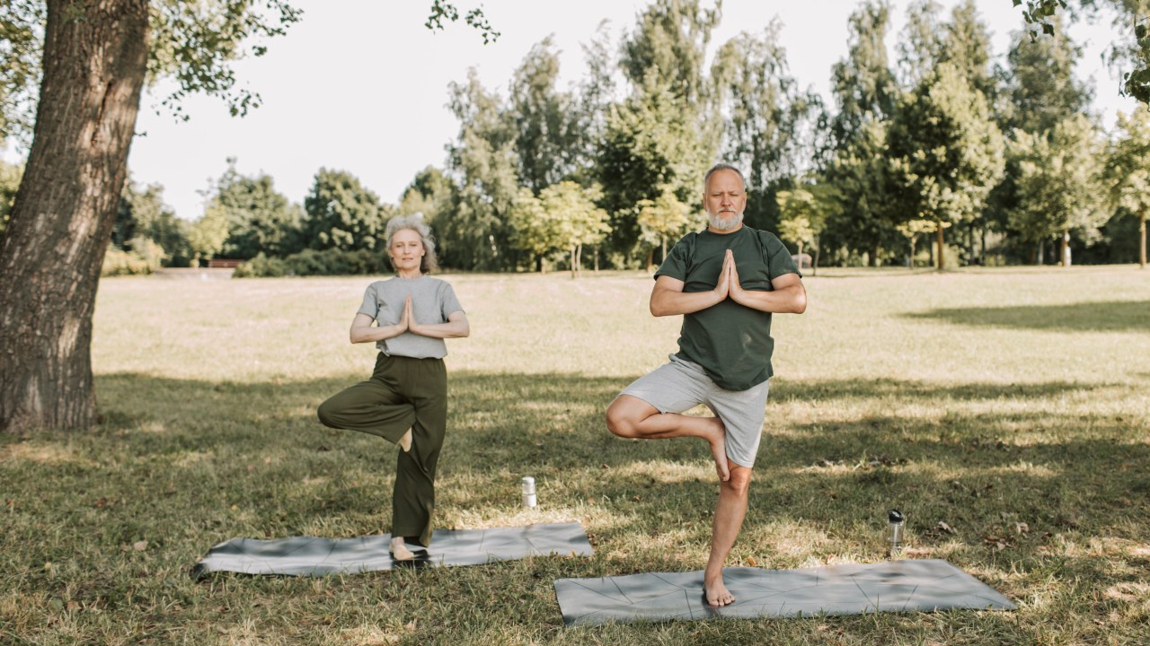 casal testando equilibrio em pose de yoga