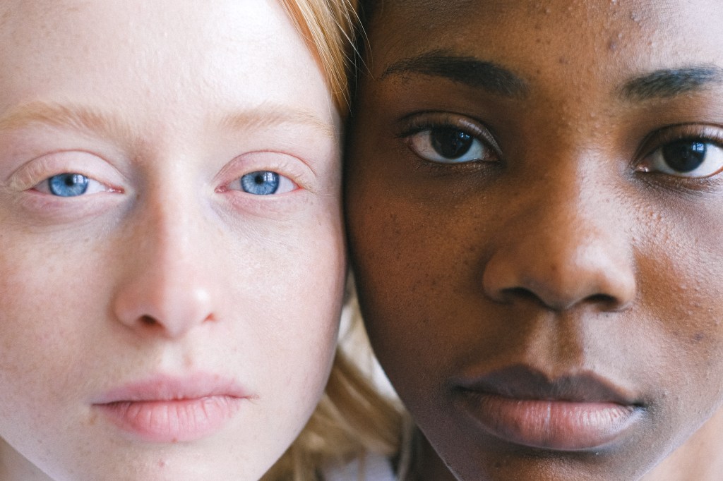 close do olhar de uma mulher branca com olhos azuis e uma mulher negra com olhos castanhos
