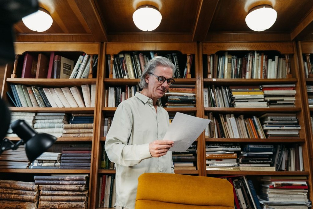Homem idoso lendo em uma biblioteca