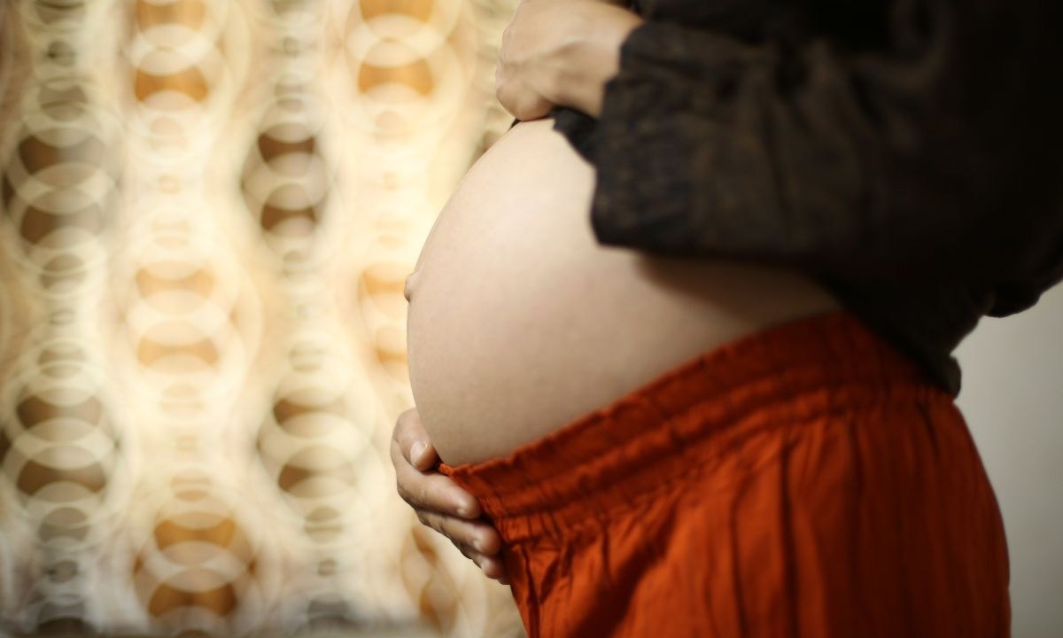 Mulher grávida com a mão na barriga