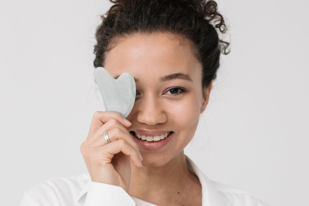 massageadores-faciais (4) Mulher tampando o olho com o massageador Gua Sha