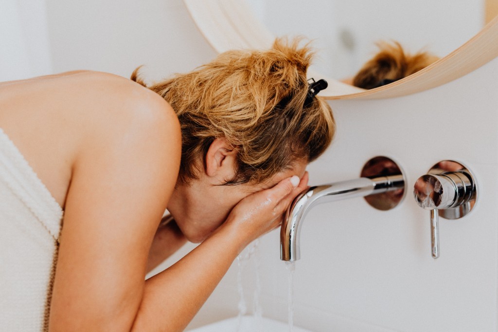 Mulher lavando o rosto