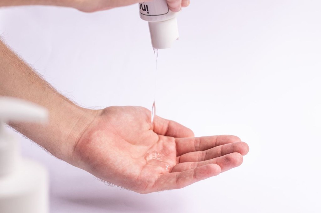 Pessoa aplicando cosmético em gel na mão