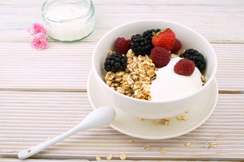 Tigela com iogurte, cereal e frutas vermelhas