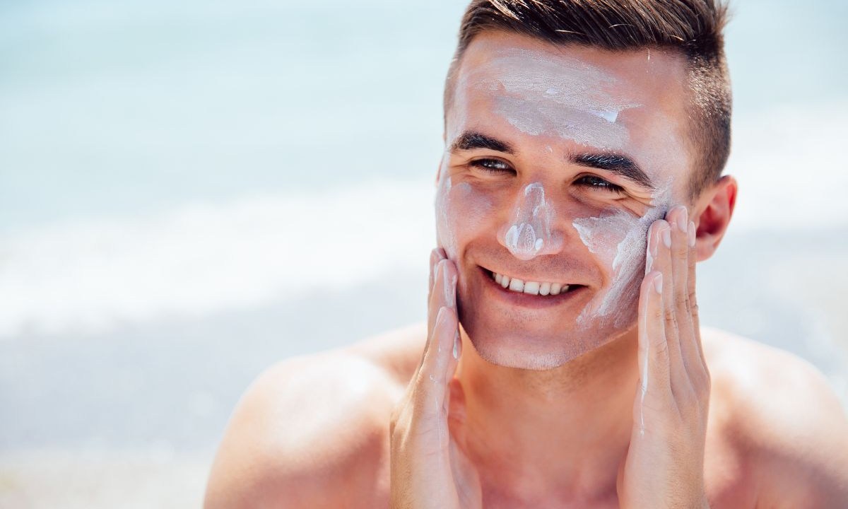 Homem aplicando protetor solar no rosto