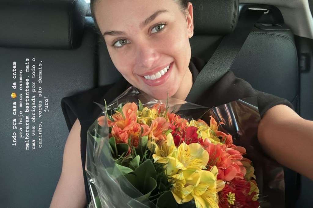 Flavia Pavanelli com buquê de flores dentro de um carro