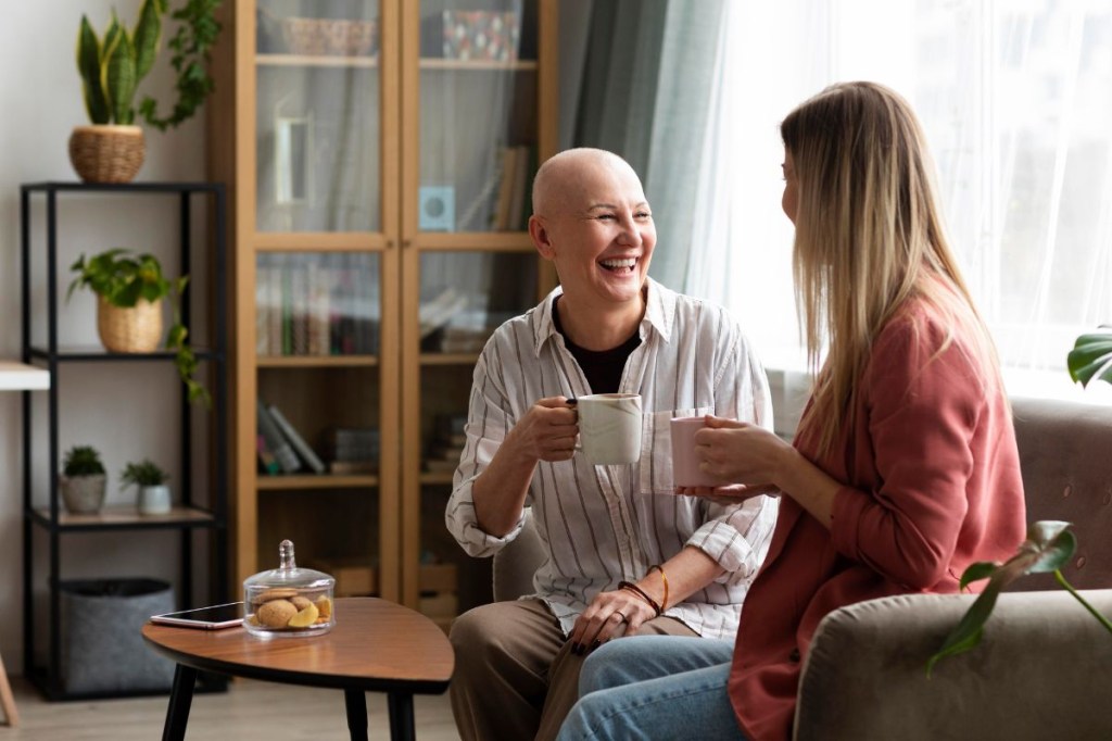 Mulher em tratamento oncológico conversando com outra mulher