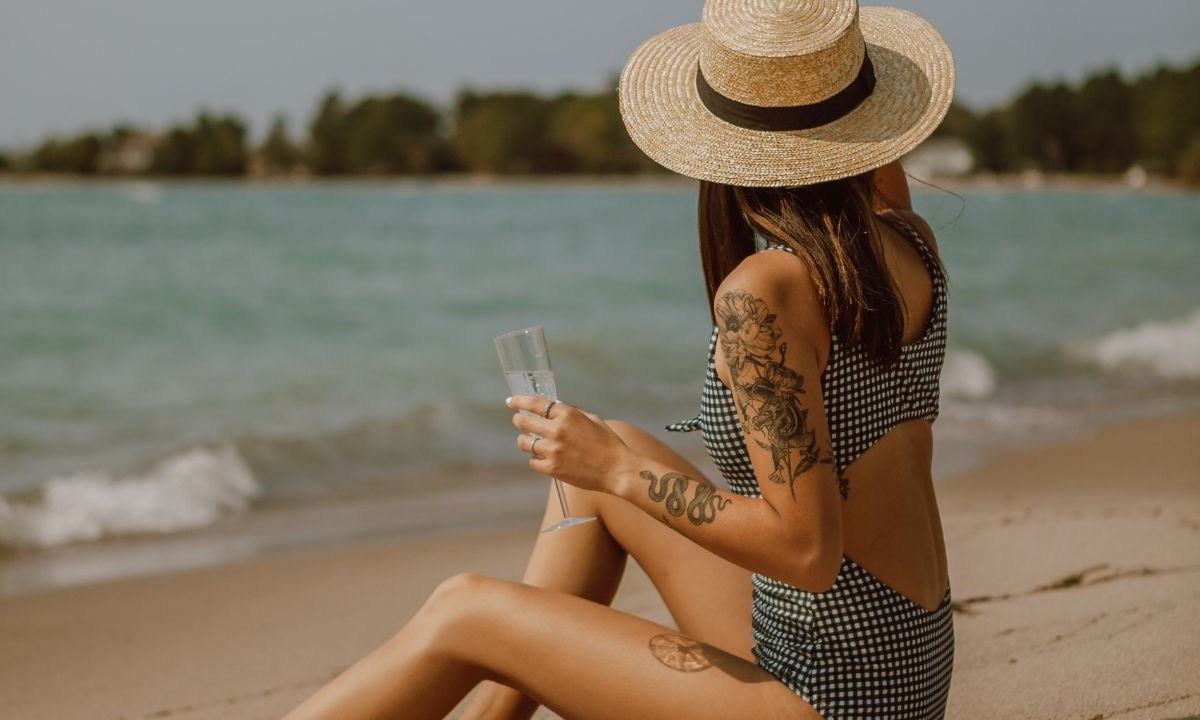Mulher tatuada na beira da praia