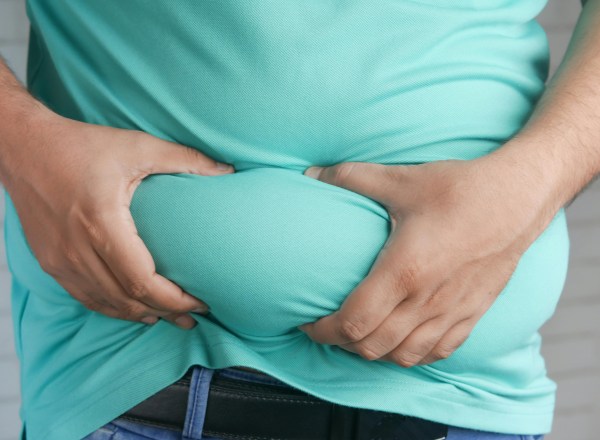 Homem com as mãos no estômago