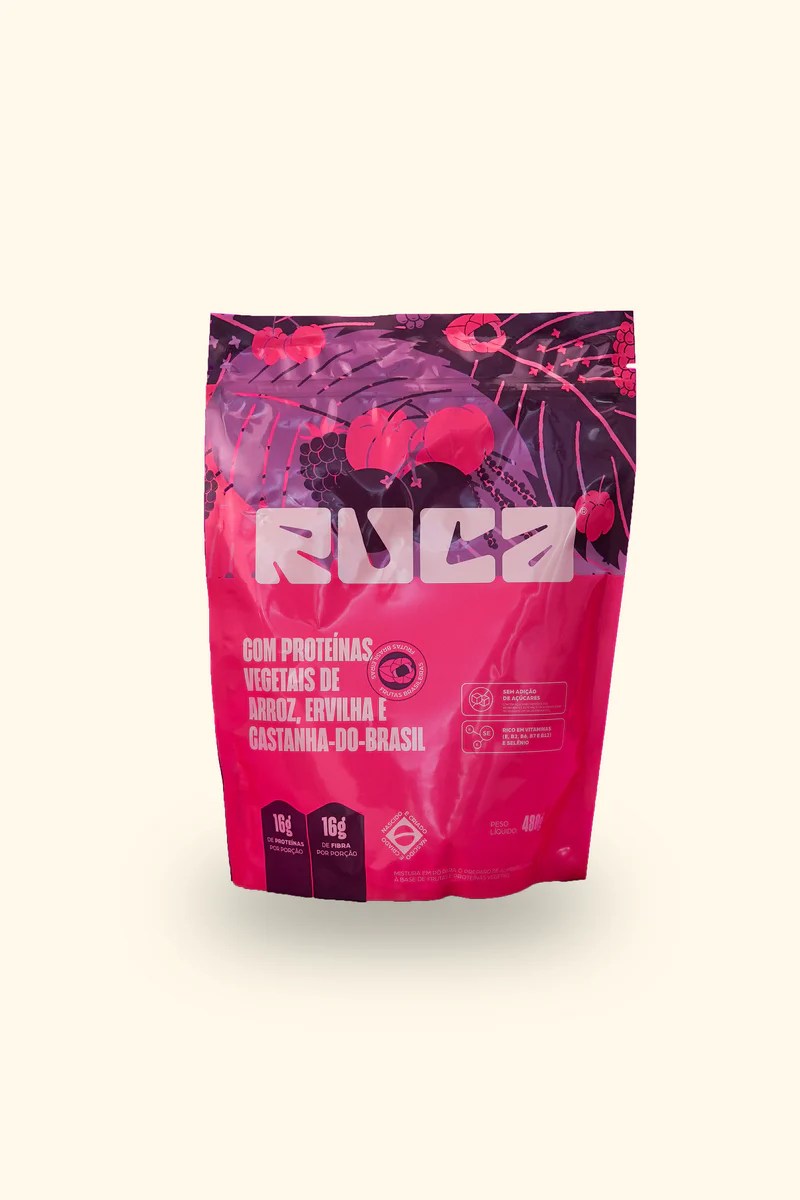 Embalagem rosa e roxa de suplemento RUA, com proteínas vegetais de arroz, ervilha e castanha-do-brasil, 16g de proteínas e fibras por porção, sem adição de açúcares, rico em vitaminas B3, B6, B7 e B12